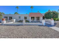 Charming single-story home featuring a red tile roof, decorative rock landscaping, and a secure gated front entrance at 11041 N 44Th St, Phoenix, AZ 85028