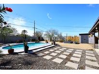 Backyard oasis with a sparkling pool, mature landscaping, and tranquil atmosphere at 1515 E Sunnyslope Ln, Phoenix, AZ 85020