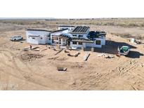 Expansive modern home under construction, featuring a unique roof and desert surroundings at 30498 N 232Nd Ave, Wittmann, AZ 85361