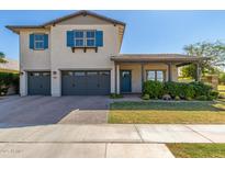 Charming two-story home with blue shutters, gray garage doors and a quaint front porch at 3623 E Arabian Dr, Gilbert, AZ 85296