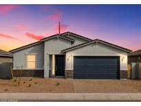 Charming single-story home with a two-car garage and desert landscaping at dusk at 4264 W Hannah St, San Tan Valley, AZ 85144