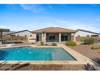 Inviting backyard oasis featuring a sparkling pool, spa and covered patio perfect for outdoor living at 4651 N 204Th Ave, Buckeye, AZ 85396