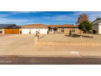 Charming single-story brick home featuring a three-car garage and low maintenance desert landscaping at 5318 W Aire Libre Ave, Glendale, AZ 85306