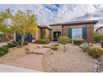 Charming single-story home featuring desert landscaping, a stone accent wall, and a brick walkway at 5921 E Ocupado Dr, Cave Creek, AZ 85331