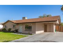 Single-story home featuring a well-maintained lawn and a convenient covered carport at 699 W Shannon St, Chandler, AZ 85225