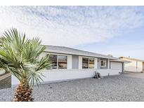 Charming single-story home featuring a well-maintained front yard, white brick facade, and inviting curb appeal at 10407 W Mission Ln, Sun City, AZ 85351