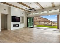 Spacious living room with a fireplace, ceiling fan, and sliding glass doors to the outdoor space at 13763 N Campsite Ct, Fountain Hills, AZ 85268