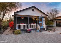 Charming home featuring a quaint front porch adorned with colorful flowers and an inviting paver walkway at 1546 W Polk St, Phoenix, AZ 85007