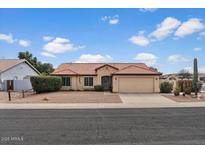 Charming single-story home featuring a tile roof, desert landscaping, and an attached two-car garage at 1651 E Kielly Ln, Casa Grande, AZ 85122