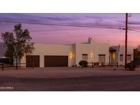 Elegant home featuring a two-car garage, desert landscaping, and a charming flag at 1775 N Starr Rd, Apache Junction, AZ 85119