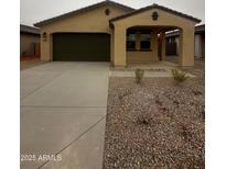 Charming single-story home with a two-car garage, covered porch, desert landscaping, and modern design at 37582 W San Clemente St, Maricopa, AZ 85138