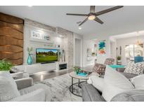 Bright living room features a stone accent wall, sleek fan, and comfortable seating arrangement at 3932 E Torrey Pines Ln, Chandler, AZ 85249