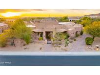 Stunning home with desert landscaping, iron gate, and paver walkway at sunset at 10396 N 133Rd St, Scottsdale, AZ 85259