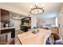 Bright dining area featuring a wooden table, modern lighting, and an open view to the kitchen and living room at 1223 N Granite Reef Rd, Scottsdale, AZ 85257
