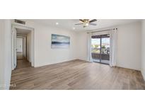 Bright living room featuring hardwood floors, a ceiling fan, and a sliding door leading to a balcony at 16657 E Gunsight Dr # 233, Fountain Hills, AZ 85268