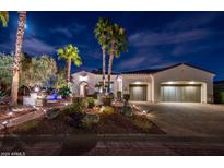 Charming home featuring a well-manicured front yard with palm trees and a classic garage door design at 22329 N Padaro Dr, Sun City West, AZ 85375