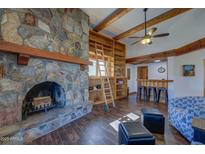Inviting living room showcasing a stone fireplace, built-in shelves, and warm wooden beam accents at 40445 N 32Nd St, Cave Creek, AZ 85331