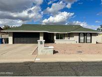 Charming single-story home with a green roof and a two-car garage, set against a beautiful blue sky at 718 W Paseo Way, Tempe, AZ 85283