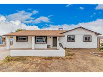 Charming single-story home featuring a brown roof, textured white exterior, and front porch at 11403 N 57Th Dr, Glendale, AZ 85304