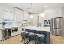 Bright kitchen featuring white cabinets, stainless steel appliances, and a large center island with bar seating at 18282 N 92Nd St, Scottsdale, AZ 85255