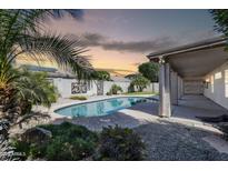 Backyard showcasing a refreshing pool, a covered patio, palm trees and nice landscaping at 318 E Gail Dr, Gilbert, AZ 85296