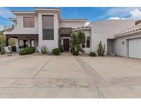 Stunning desert home featuring a spacious driveway, lush landscaping, and a modern stucco exterior at 4822 S Gold Canyon Dr, Gold Canyon, AZ 85118