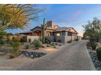 Stunning exterior features desert landscaping, a paved driveway, and a welcoming entrance to the house at 7363 E Lower Wash Pass, Scottsdale, AZ 85266