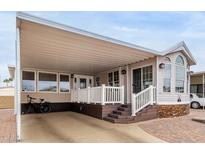 Charming manufactured home featuring a covered parking area, well-manicured landscaping, and stone accents at 7750 E Broadway Rd # 54, Mesa, AZ 85208