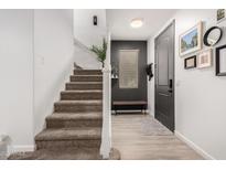 Inviting entryway with a modern gray door and a staircase leading to the upper level at 7840 W Bonitos Dr, Phoenix, AZ 85035