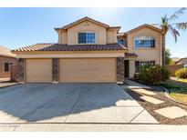 Two story home featuring a tile roof, three car garage, and neutral desert landscaping at 835 E Stirrup Ln, San Tan Valley, AZ 85143