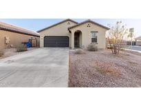 Charming home featuring a two-car garage, desert landscaping, and a welcoming arched entryway at 9539 W Agora Ln, Tolleson, AZ 85353