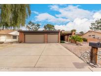 Charming brick home featuring a two-car garage, manicured landscaping and mature trees at 16631 N 36Th Ave, Phoenix, AZ 85053