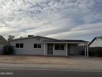 Charming single-story home with a covered parking and a well-maintained front yard at 1853 W Burgess Ln, Phoenix, AZ 85041