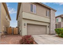 Two-story home featuring a two-car garage, desert landscaping, and modern design at 2067 N Marketside Ave, Buckeye, AZ 85396