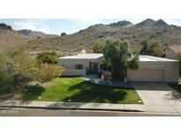 Charming single-story home with lush green lawn, beautiful desert landscaping and mountain views at 3501 E Dunlap Ave, Phoenix, AZ 85028