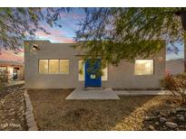 Charming single-story home with a vibrant blue front door and desert landscaping at 407 E Eason Ave, Buckeye, AZ 85326