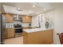 Bright kitchen features stainless steel appliances, modern countertops, and natural wood cabinetry at 12222 N Paradise Village S Pkwy # 337, Phoenix, AZ 85032