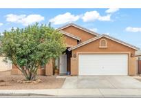 Charming single-story home featuring a two-car garage and mature landscaping at 1619 E Silverbirch Ave, Buckeye, AZ 85326