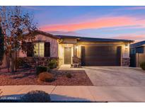 Charming single-story home featuring stone accents, a covered entryway, and a well-manicured front yard with desert landscaping at 16278 W Jenan Dr, Surprise, AZ 85379