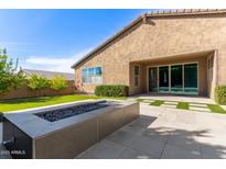 Backyard featuring green grass, a modern fire pit, and a covered patio at 3025 W Night Owl Ln, Phoenix, AZ 85085