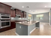 Modern kitchen with stainless steel appliances, granite counters, and a central island at 3025 W Night Owl Ln, Phoenix, AZ 85085