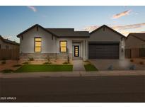 Stunning single-story home with modern architectural details, desert landscaping, and a stylish gray door at 34315 N Sandpiper Trl, Queen Creek, AZ 85144