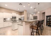 Bright kitchen view featuring an island, granite countertops, and white cabinetry at 6159 W Sequoia Dr, Glendale, AZ 85308