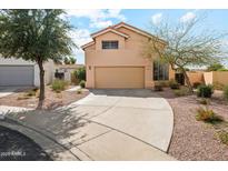 Two story home with a two car garage, a large driveway, and desert landscaping at 6717 E Saddleback Cir, Mesa, AZ 85215