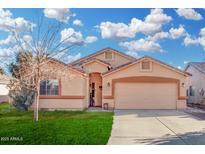 Charming single-story home features a two-car garage, a well-maintained lawn, and desert landscaping at 815 E Centre Ave, Buckeye, AZ 85326