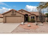 Charming single-story home with desert landscaping, a two car garage, and a terracotta tiled roof at 14404 N 56Th Pl, Scottsdale, AZ 85254