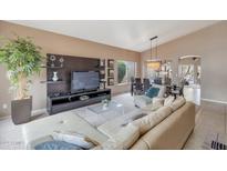 Open-concept living room with sleek entertainment center and view of dining area at 14447 N 100Th Way, Scottsdale, AZ 85260