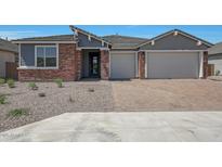 Charming single-story home with brick accents, a two-car garage, and a well-maintained desert landscaped front yard at 18432 W Mohave St, Goodyear, AZ 85338