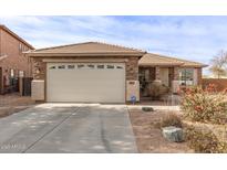 Charming single-story home featuring a two-car garage, stone accents, and a low-maintenance front yard at 20212 N Valencia Dr, Maricopa, AZ 85138