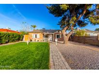 Charming brick home featuring a lush lawn, mature landscaping, and an inviting walkway to the front door at 2201 N 17Th Ave, Phoenix, AZ 85007